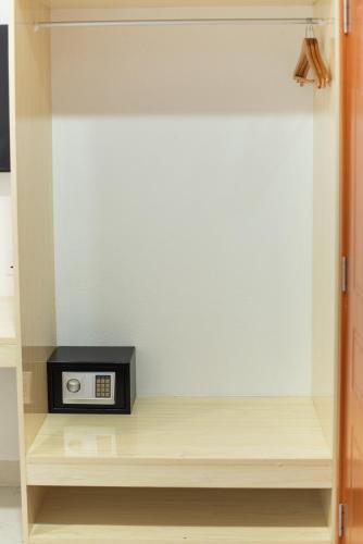 a clock sitting on a shelf in a closet at Paradise Palms - Guest House in Thoddoo