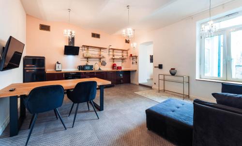 a living room with a wooden table and chairs at Silvie Apartments - Blažejský in Olomouc