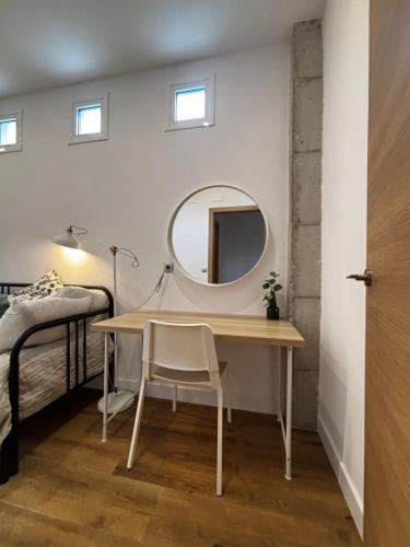 a bedroom with a desk and a mirror next to a bed at Apartamento Laredo con Terraza in Laredo