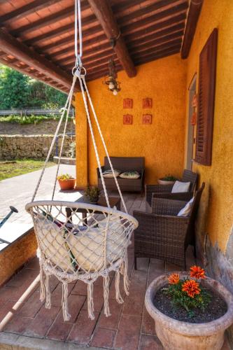 a porch with a swing and a table and chairs at Casa Magnolia in Bientina