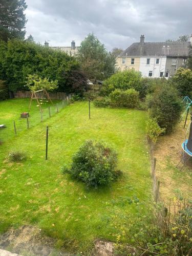 a garden with a playground in the grass at Brigadoon House Lochgilphead in Lochgilphead