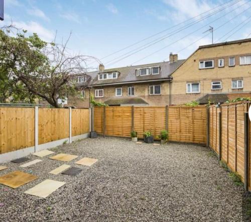 a backyard with a wooden fence at The Cosy Flat in Bethnal Green in London