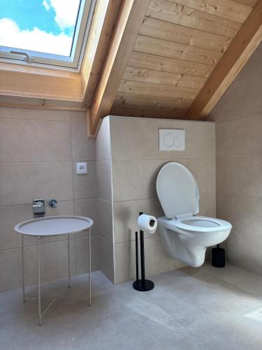 a bathroom with a toilet and a table at Apartmány Hrachov in Svatý Jan