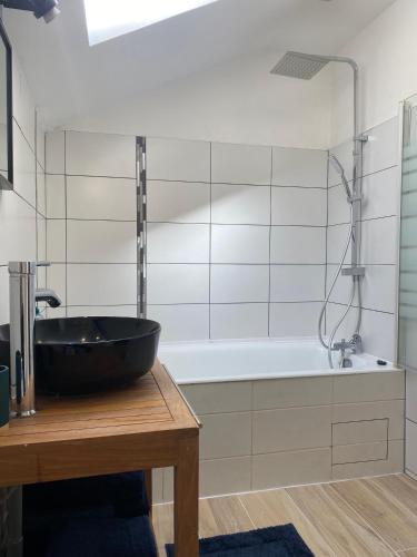 une salle de bain avec un lavabo noir sur une table en bois dans l'établissement Duplex T4 centre historique, à Aurillac