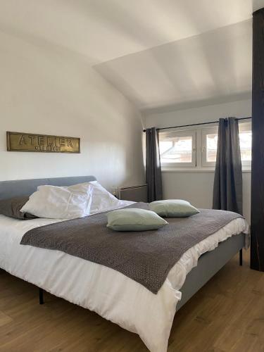 une chambre avec un lit avec deux oreillers dessus dans l'établissement Duplex T4 centre historique, à Aurillac