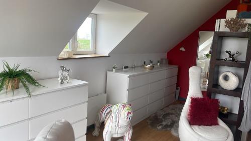 a bedroom with a white dresser and a red wall at Spacious Luxury countryside retreat in Estry