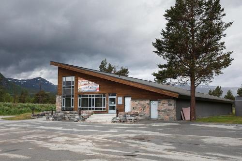 a building with a tree in front of it at Cozy apartment with pool in Bjorli