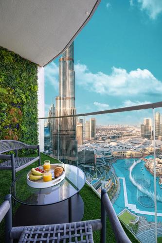 a balcony with a table and a view of a city at Stay in the #1 Burj & Fountain View 4BR Apartment in Dubai