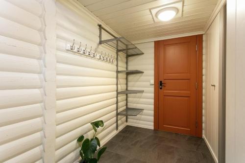 a hallway with wooden walls and a red door at Cozy apartment with pool in Bjorli