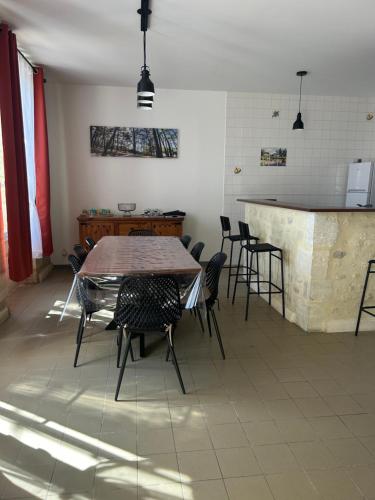 une chambre avec une table, des chaises et un bar dans l'établissement Pierres d'estuaire, à Valeyrac