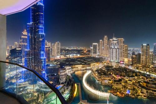 a city skyline at night with a tall building at Stay in the #1 Burj & Fountain View 4BR Apartment in Dubai