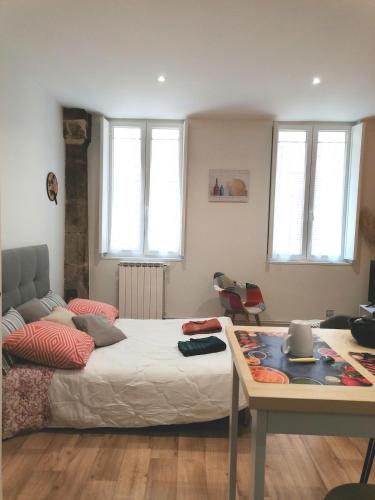 une chambre avec un lit, une table et des fenêtres dans l'établissement STUDIO Rénové 26 m2 Centre Historique, à Rodez