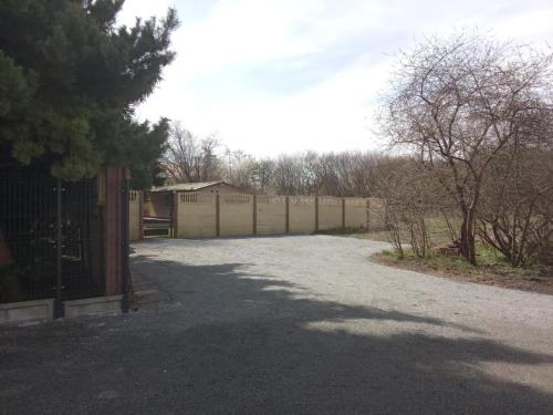 a parking lot with a fence and a driveway at Klimatyzowany domek letniskowy Świnoujście in Świnoujście