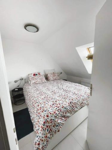 une chambre avec un lit avec un couvre-lit fleuri dans l'établissement Appartement face à la mer, à Guidel