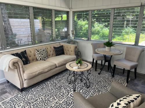 a living room with a couch and tables and windows at cozy retreat in upscale Green Hills in west Nashville in Nashville