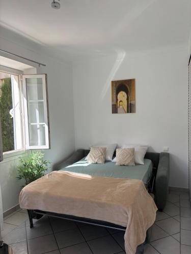un lit dans une chambre avec un tableau sur le mur dans l'établissement Cozy studio sur la promenade, à Nice