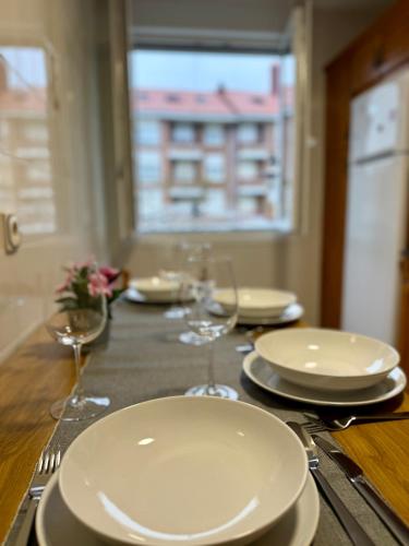 a table with plates and wine glasses on it at Piso Familiar San Vicente de la Barquera in San Vicente de la Barquera
