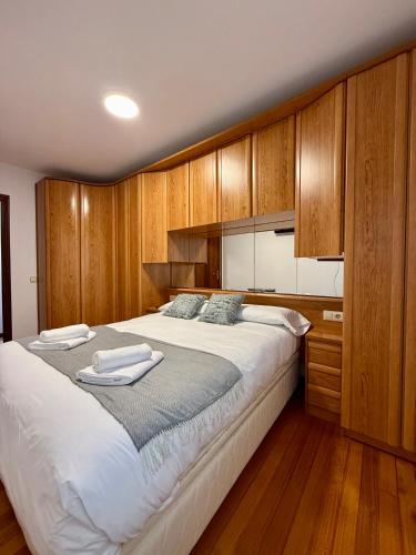 a bedroom with a large bed with wooden cabinets at Piso Familiar San Vicente de la Barquera in San Vicente de la Barquera