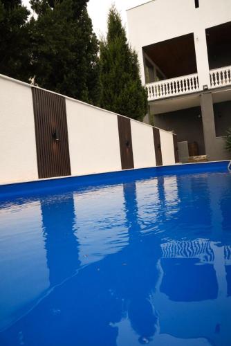 a blue swimming pool in front of a white fence at Villa Aragvi in Mtskheta