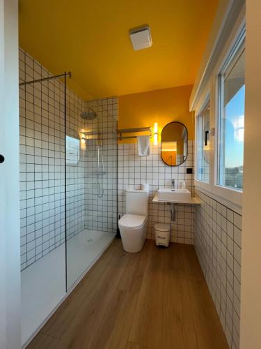 a bathroom with a sink and a toilet and a mirror at Albergue O Burgo in O Pedrouzo