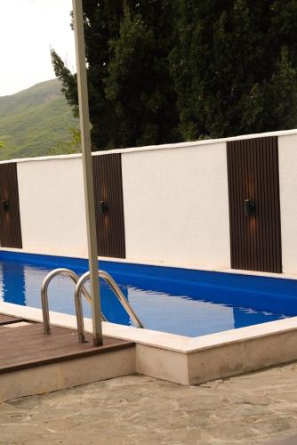 a swimming pool next to a white and blue fence at Villa Aragvi in Mtskheta