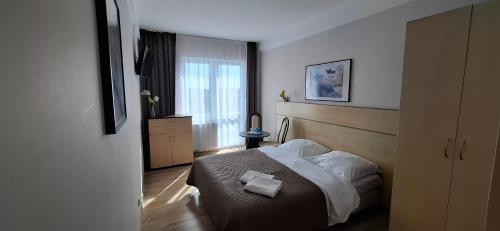 a bedroom with a bed and a window at Koral in Władysławowo