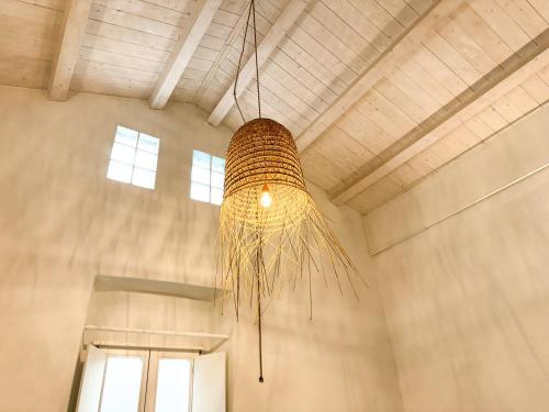 a wicker chandelier hanging from the ceiling of a building at Kalma Lux - Sant Efisio Lofts in Cagliari