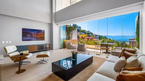 a living room with a couch and a large window at PH 10 - SoHo PV in Puerto Vallarta