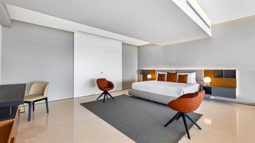 a bedroom with a bed and a desk and chairs at PH 10 - SoHo PV in Puerto Vallarta