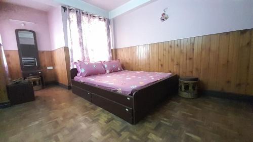 a small bed in a room with a window at sunset nest Drokpas rest heart of Darjeeling in Darjeeling