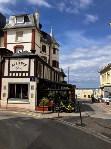 a building with a motorcycle parked in front of it at Trouville Palace Le Bonheur in Trouville-sur-Mer