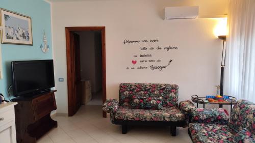 a living room with a chair and a tv at Katy's Garden in Anzio