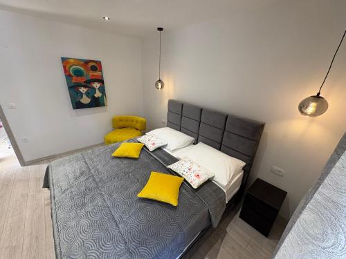 Un dormitorio con una cama grande con almohadas amarillas. en Marco Polo House, en Grohote