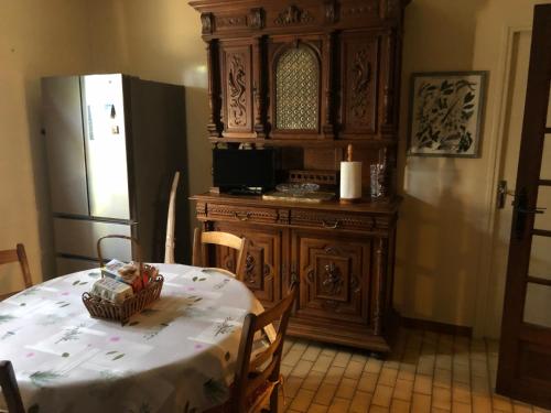 une cuisine avec une table et un réfrigérateur dans l'établissement La maison de Mimi, à Ribiers