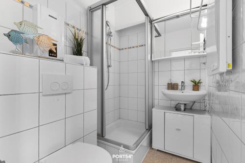 une salle de bain blanche avec une douche et un lavabo dans l'établissement Ferienwohnung Weitblick Marina Wendtorf, à Wendtorf