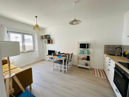 a kitchen and living room with a table and a dining room at Casa do Viajante - Family in Zambujeira do Mar