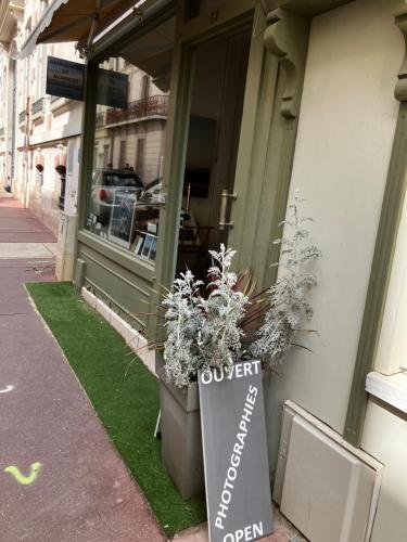 a sign on the side of a store with flowers at Trouville Palace Le Bonheur in Trouville-sur-Mer