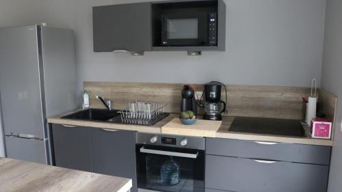 une cuisine avec un évier et un micro-ondes dans l'établissement Apartment in a quiet residence, à Concarneau