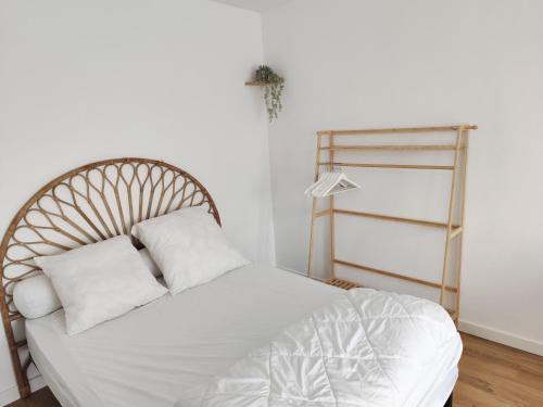 un lit avec des draps blancs et des oreillers dans une chambre dans l'établissement Studio 150m de la mer, à Berck-sur-Mer