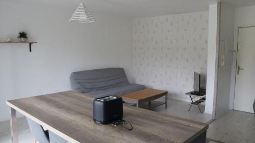 un salon avec un canapé et une table dans l'établissement Apartment in a quiet residence, à Concarneau