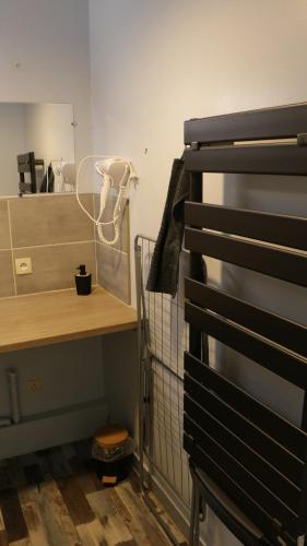 Cette chambre comprend un bureau, une table et une étagère. dans l'établissement Apartment in a quiet residence, à Concarneau