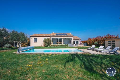 une maison avec une piscine dans une cour dans l'établissement Villa moderne avec piscine dans village calme, à Vénéjan