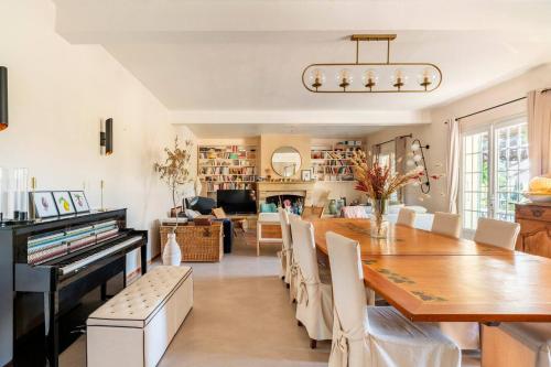 une salle à manger avec une table et un piano dans l'établissement Le mas des vignes, à Rochegude