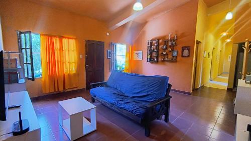 a living room with a blue couch and a table at Jujuy Hub Hostel in Reyes