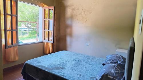 a bedroom with a bed and an open window at Jujuy Hub Hostel in Reyes