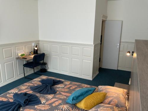 a bedroom with a bed with blue pillows on it at Hotel Poseidon in Scheveningen