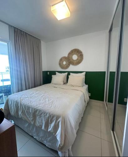 a bedroom with a large bed with white sheets at Cobertura 435 - In mare bali in Parnamirim