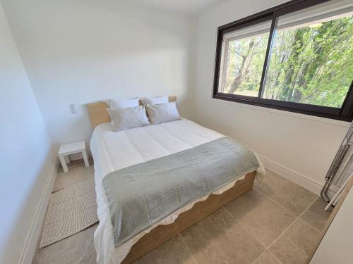 une chambre avec un grand lit avec une fenêtre dans l'établissement T2 idéal à 50m de la plage Tout à pied Parfait pour des vacances relax, à Cavalaire-sur-Mer