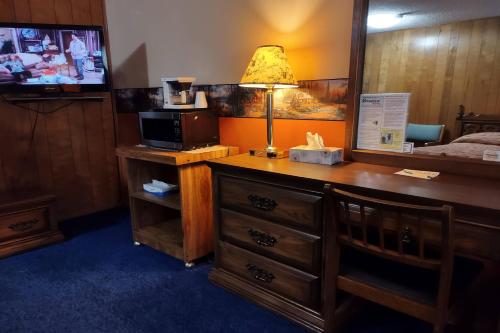 a room with a desk with a microwave and a television at Love Hotels Voyageur by OYO at International Falls MN in International Falls