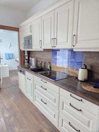 a kitchen with white cabinets and a sink at Villa Meeresglück in Sassnitz